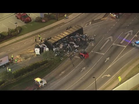 Tractor trailer overturns, spilling car parts on Jimmy Carter Blvd